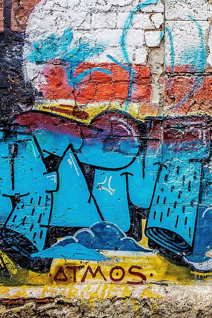 A wall with graffiti on it and a fire hydrant in front of it ...