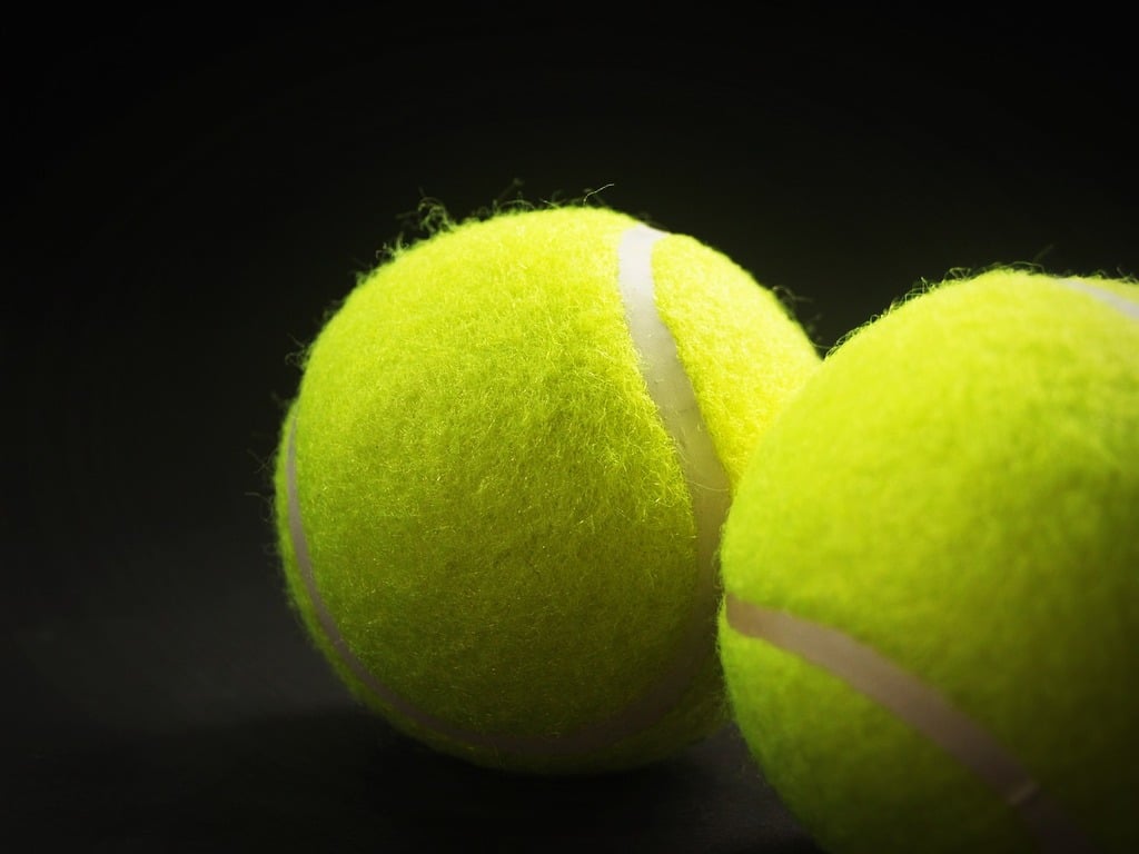 Tennis - Tennis ball with white string on black background