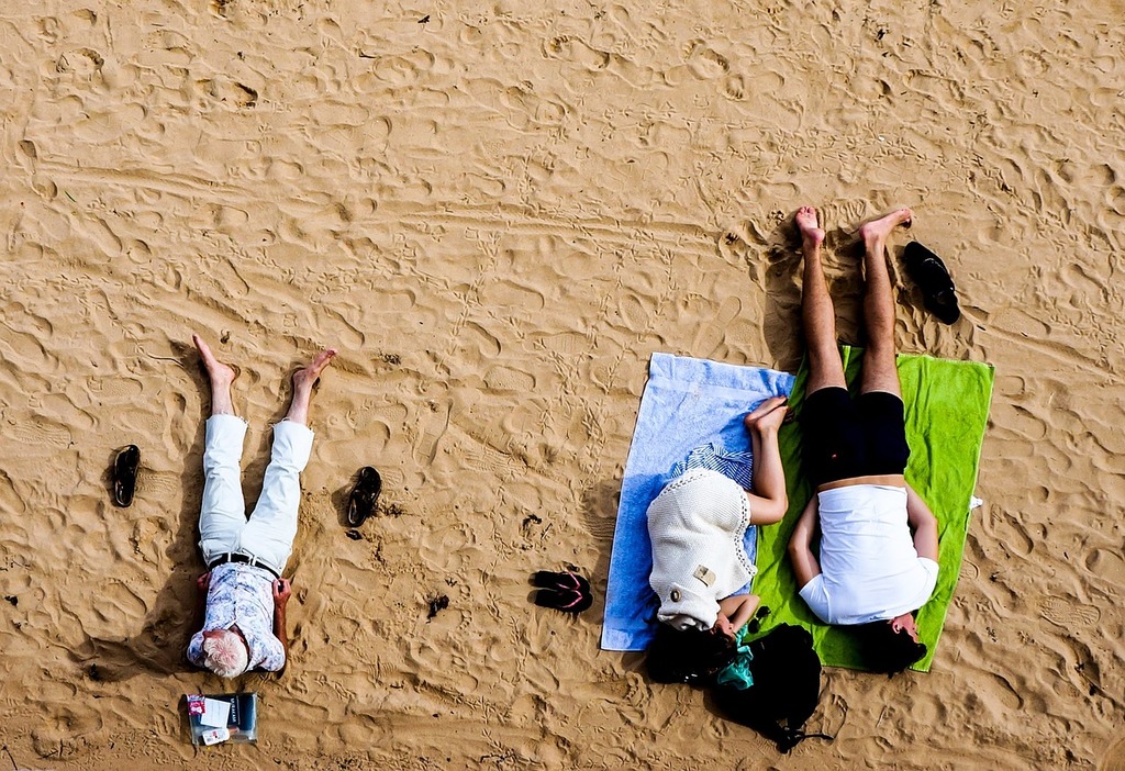 A couple of people laying on top of a sandy beach. Beach sand people -  PICRYL - Public Domain Media Search Engine Public Domain Image