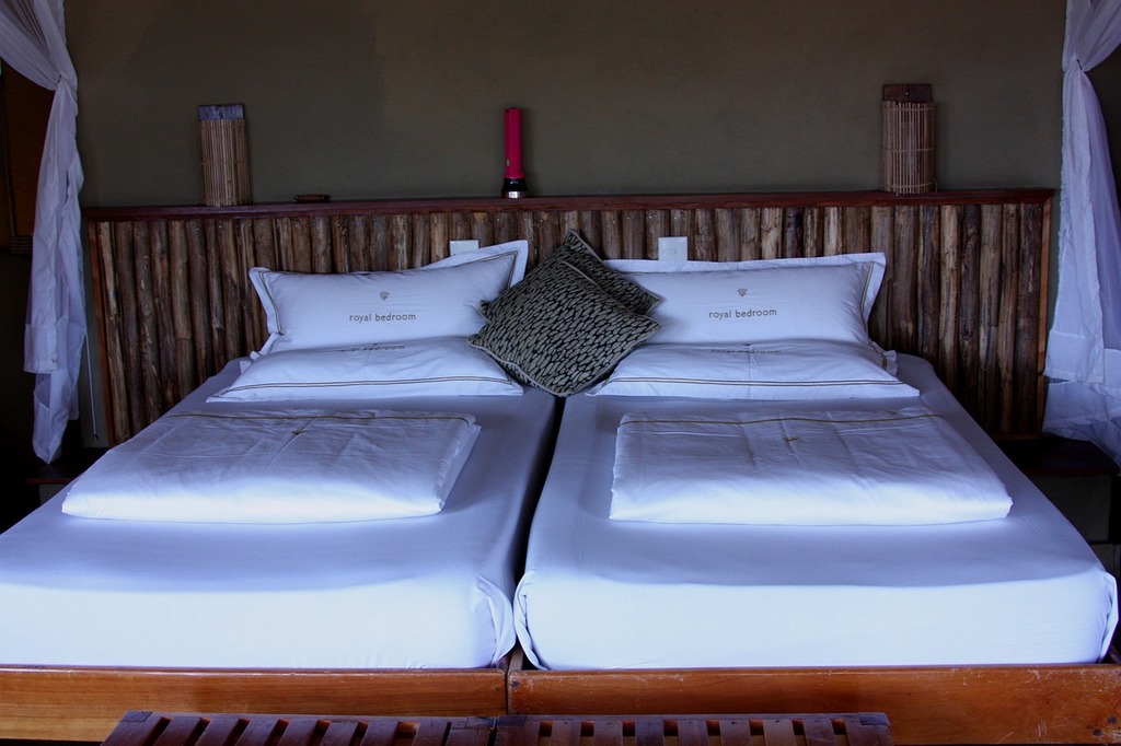 Yellow pillow and blanket on white bedding in simple hotel room Stock Photo  by bialasiewicz