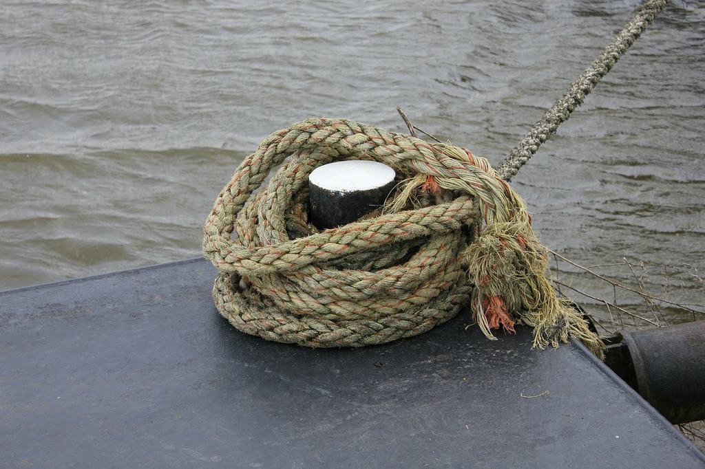 A rope wrapped around a pole on a boat. Boat anchor rope. - PICRYL