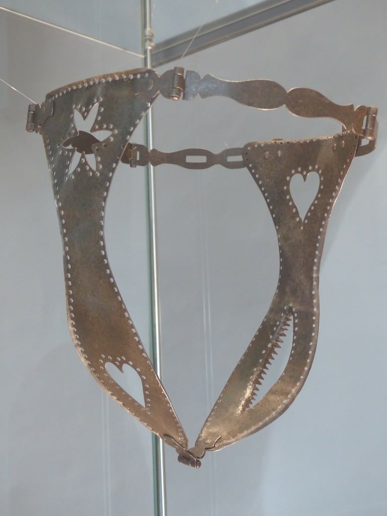 A close up of a metal object in a glass case. Chastity belt middle ages  instrument of torture, beauty fashion. - PICRYL - Public Domain Media  Search Engine Public Domain Search