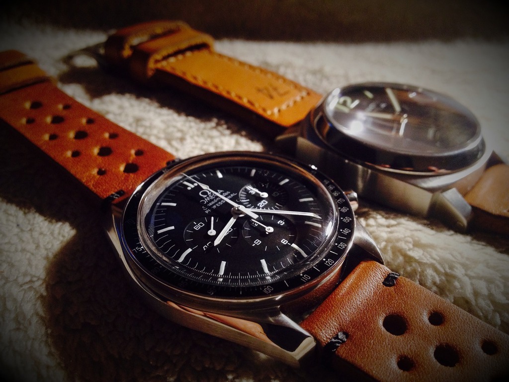 A couple of watches sitting next to each other. Clock panerai