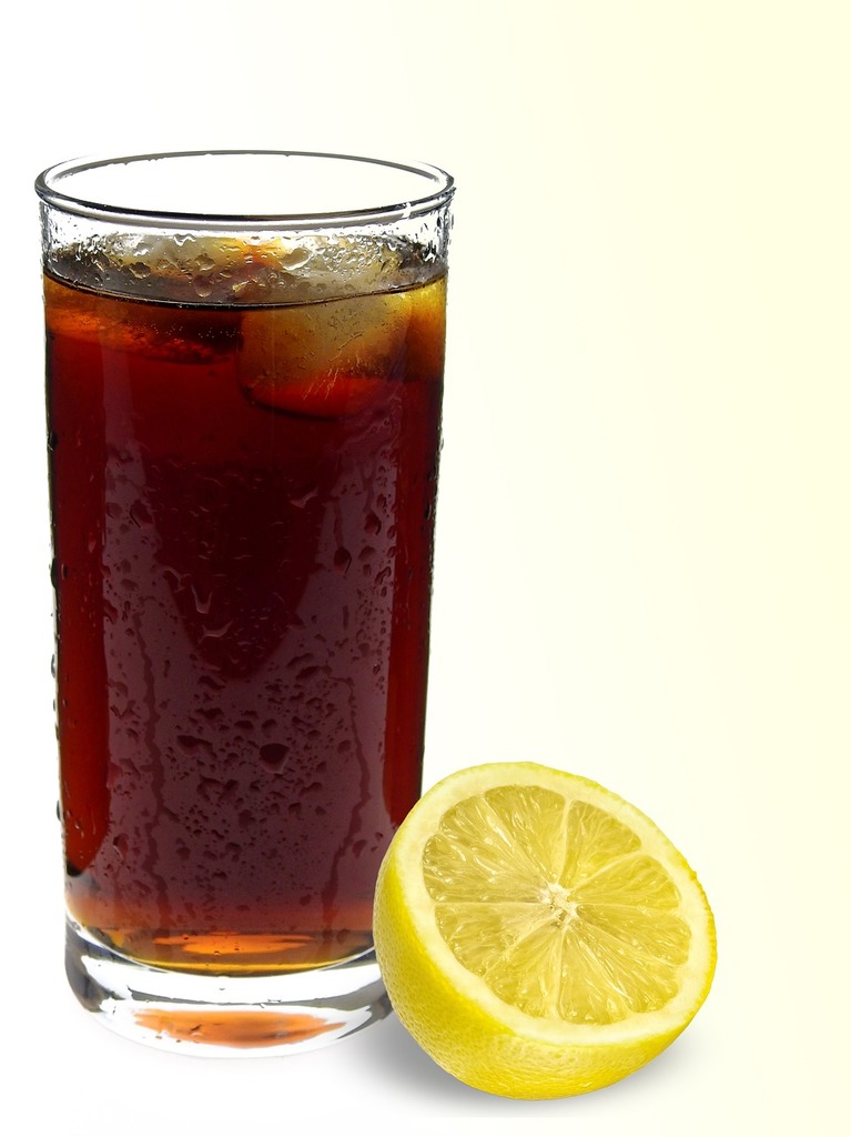 A glass of soda next to a lemon. Cola drink refreshment. - PICRYL