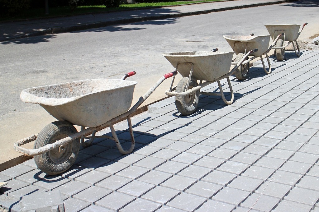 A row of cement wheelbarrows on a sidewalk. Construction work