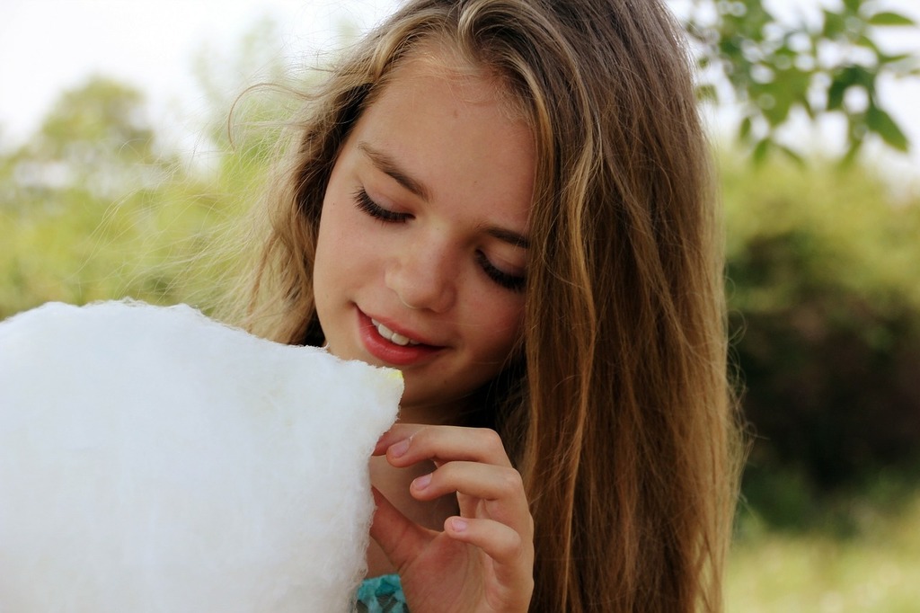 A young girl holding a cotton candy floss. Cotton candy sweet girl