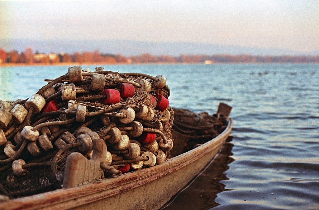 A boat filled with lots of buoys sitting on top of a body of water