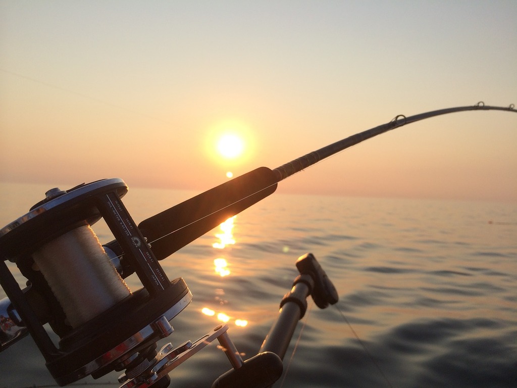 A fishing rod and reel on a boat at sunset. Fishing fishing rod