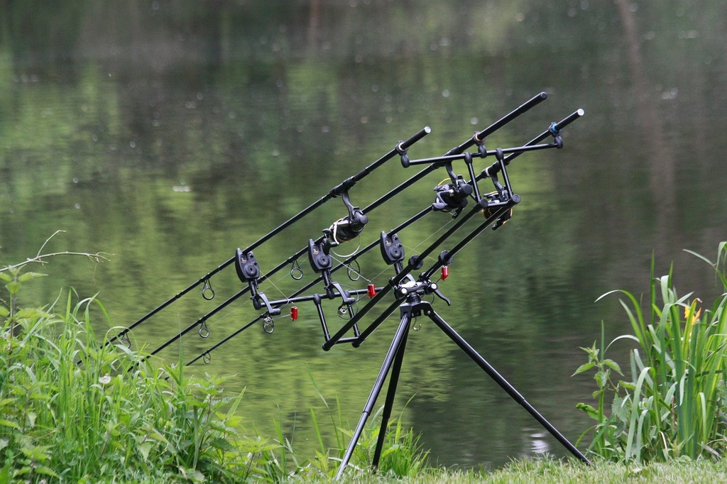 A group of fishing rods sitting on top of a tripod. Fishing rods pond  green. - PICRYL - Public Domain Media Search Engine Public Domain Search