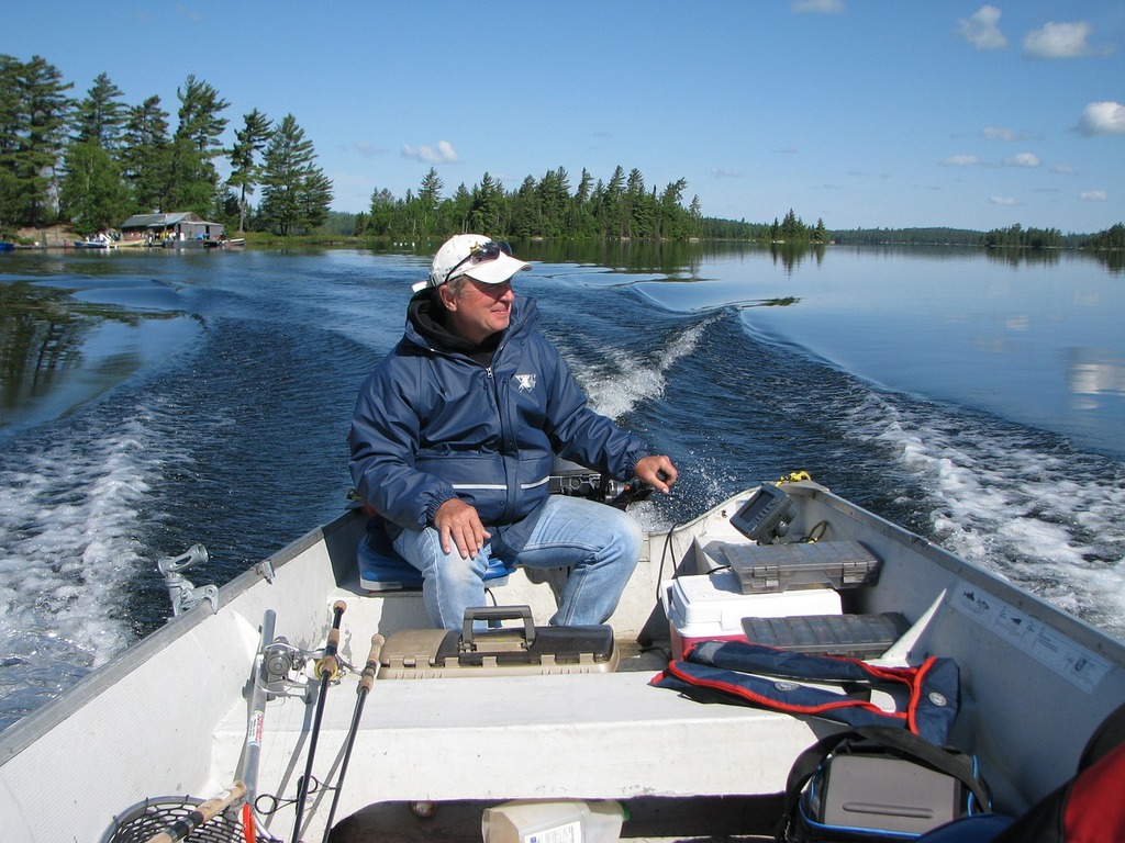 A man sitting in a boat on a lake. Fishing trip fishing canada