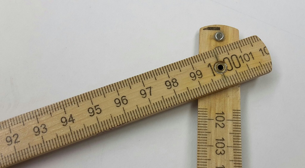 Measuring tape stretched 21 cm on a wooden background. Close-up