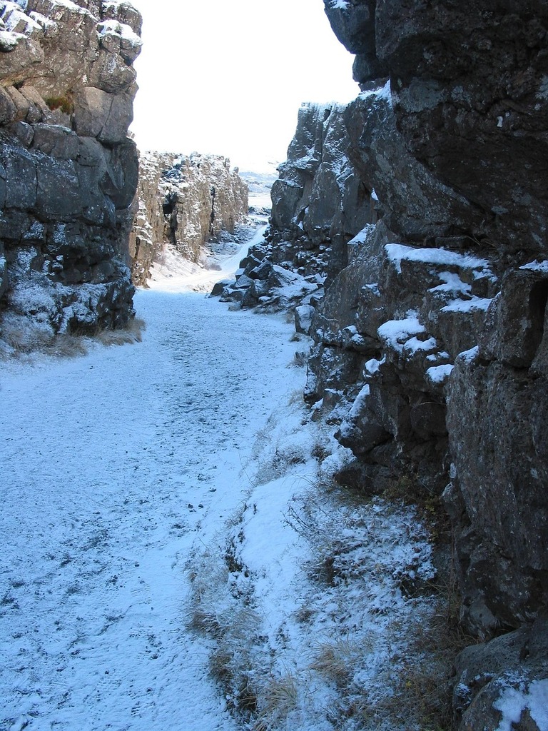 A person on a snowboard on a snowy trail. Golden circle iceland