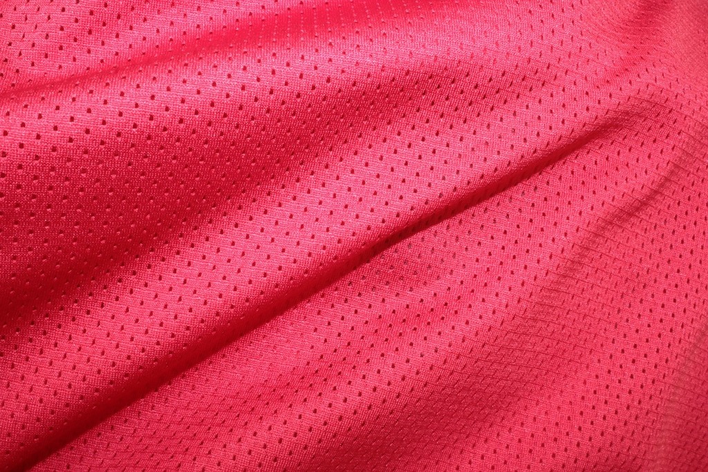A close up view of a red shirt. Red cloth background red cloth red
