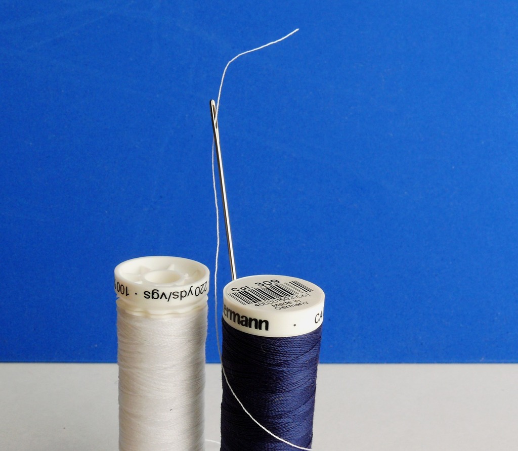 A bunch of spools of thread on a table. Weaving spool coil