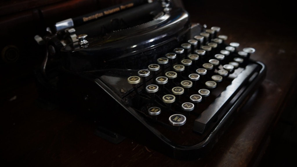 An old typewriter sitting on top of a wooden table. Old typewriter