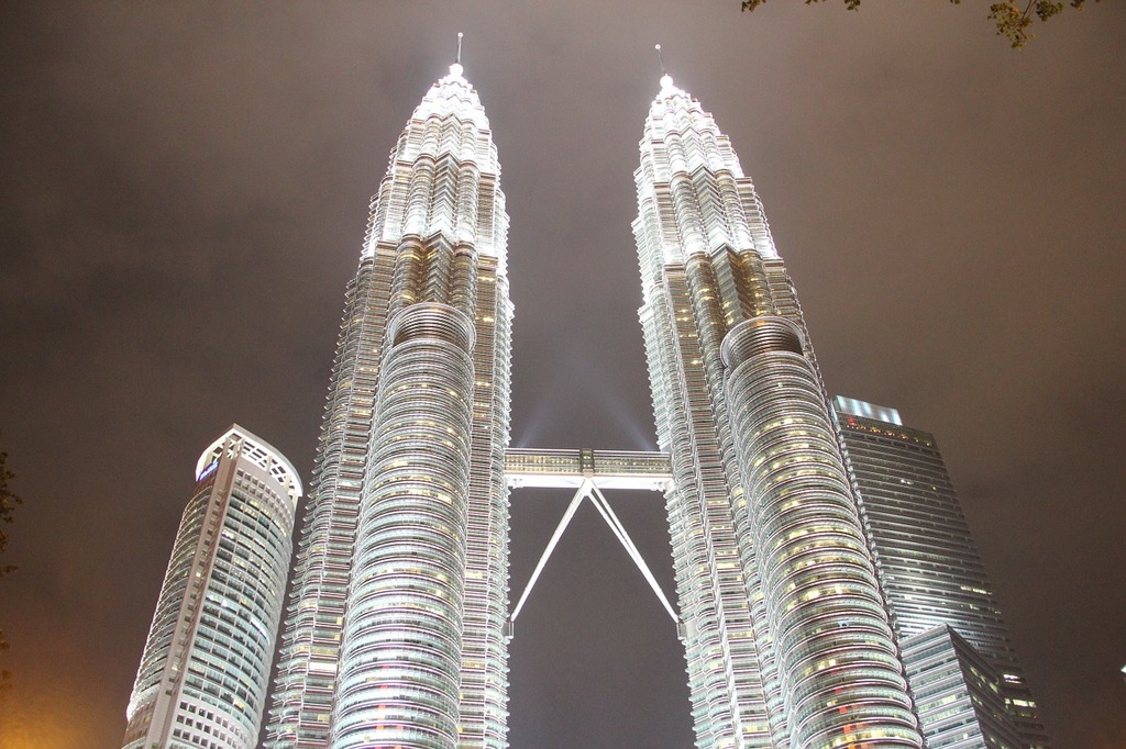 A couple of tall buildings lit up at night. Petronas towers klcc kuala ...