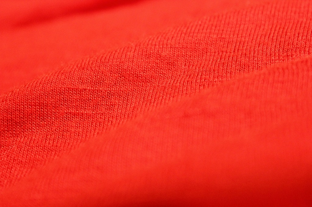 A close up view of a red shirt. Red cloth background red cloth red