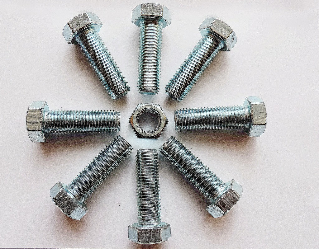 A group of nuts and bolts arranged in a circle. Screw metal thread