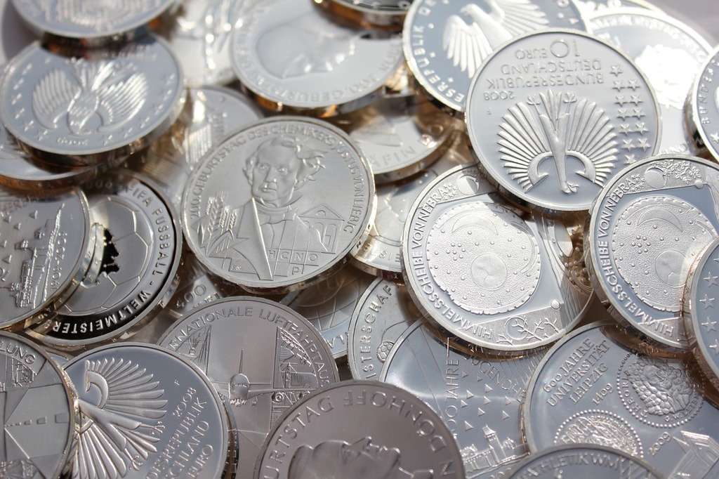 A pile of silver coins sitting on top of a table. Silver coins