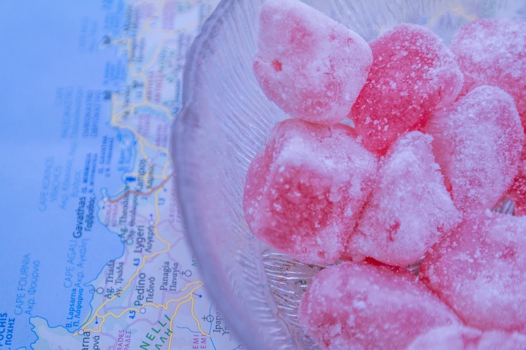 A Glass Bowl Filled With Sugar Cubes On Top Of A Map. Turkish Delight 