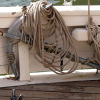 A close up of a rusty anchor on a rope. Anchor sea port. - PICRYL